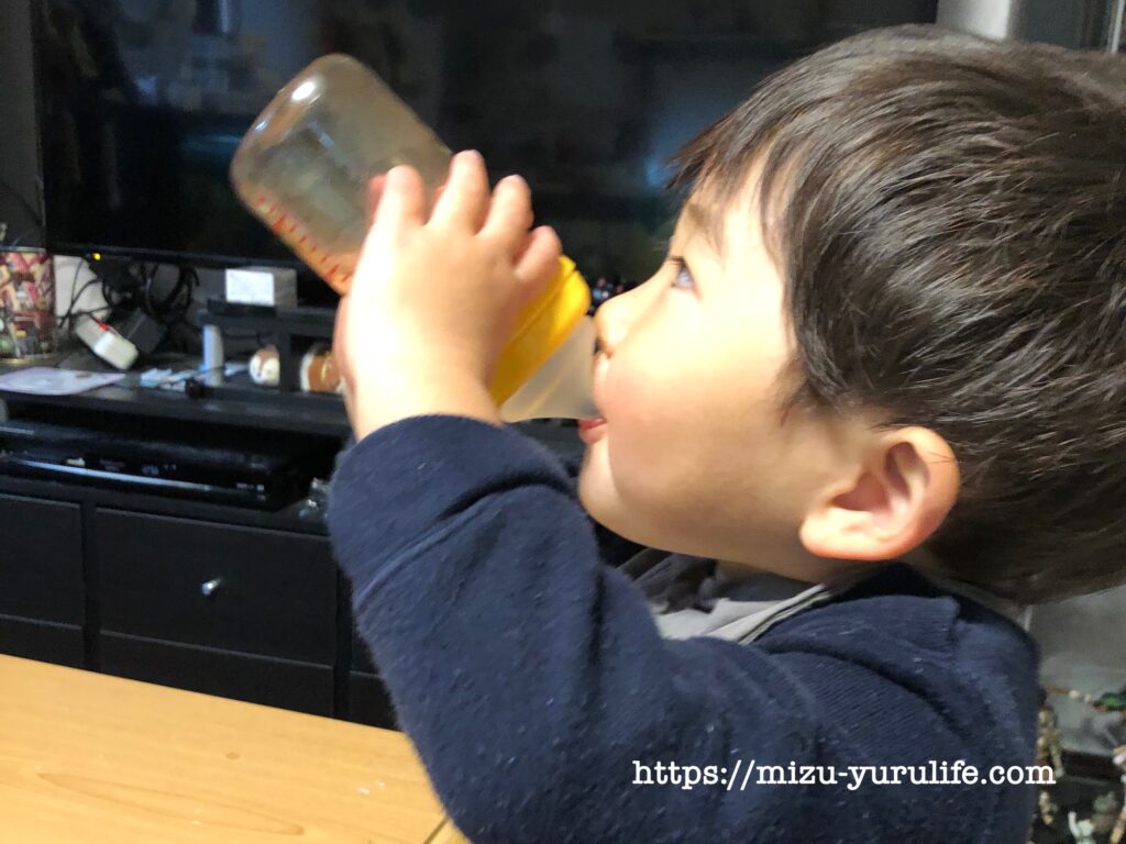 哺乳瓶で水分補給をする２歳